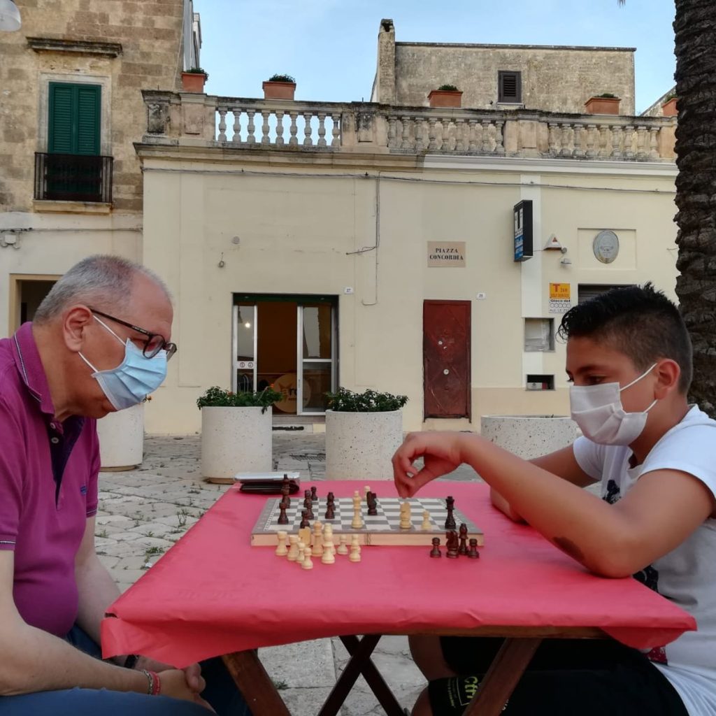 Anziano e bambino giocano a scacchi
